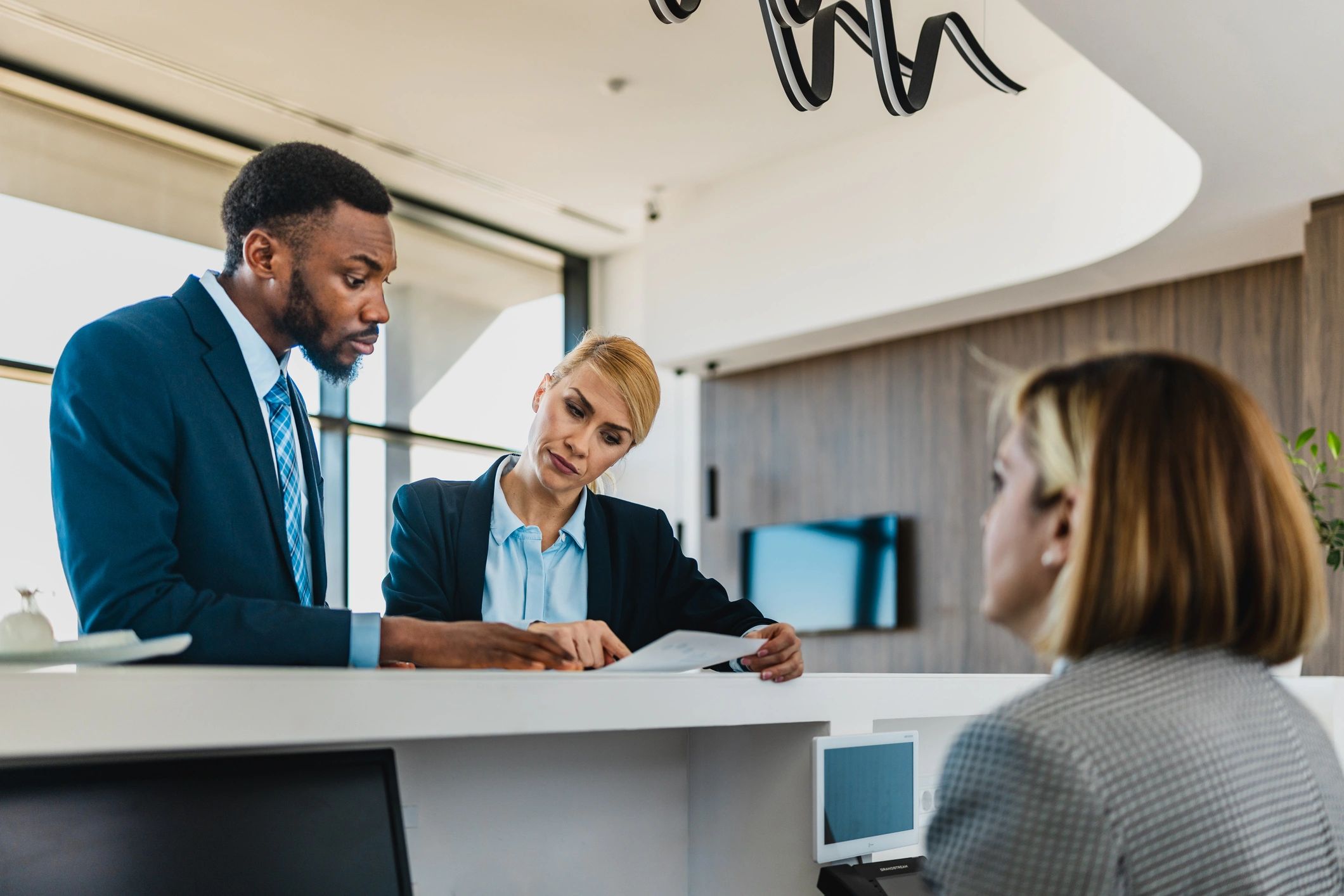 Asesores revisando opciones de viaje con clientes en una oficina moderna